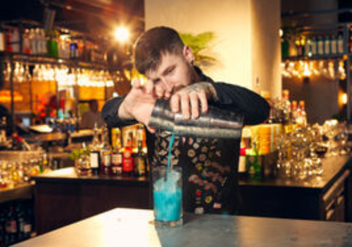 A man serving drink to customer in TGI Fridays